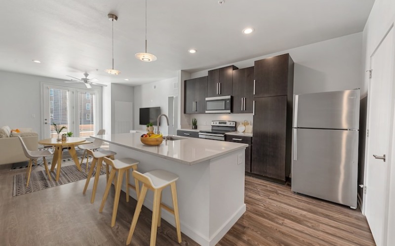 Model kitchen at our apartments for rent in Midland, TX, featuring wood grain floor paneling and stainless steel appliances.