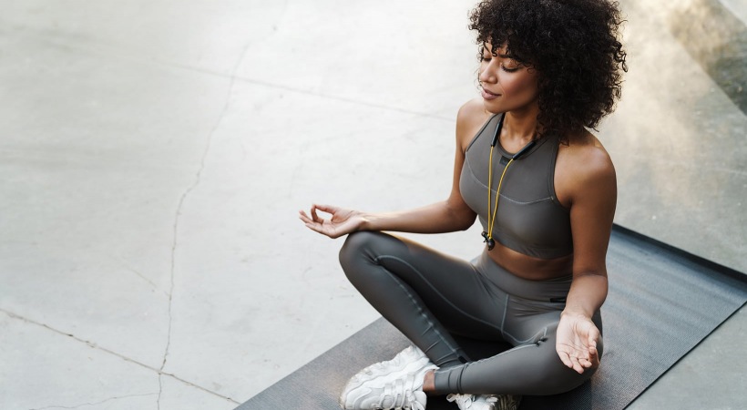 lifestyle image of a woman sitting in a meditation stance