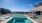 The pool area at our apartments for rent in Midland, TX, featuring beach chairs and a view of the apartments.